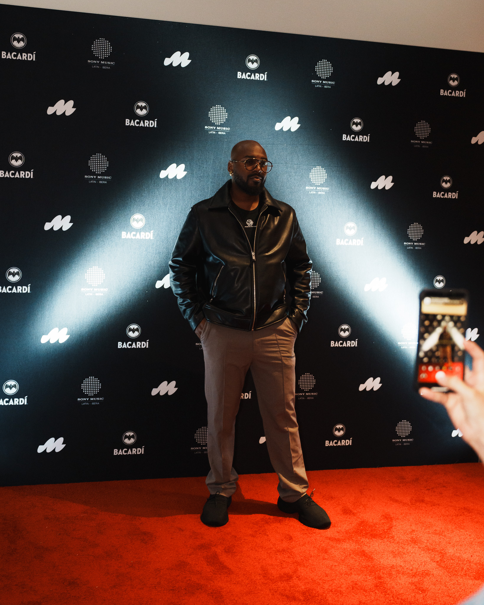 Guest posing on the Sony Music and Bacardi event backdrop